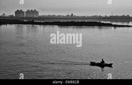 Leben am Nil in Ägypten, Fischer Rudern durch Haus Stockfoto