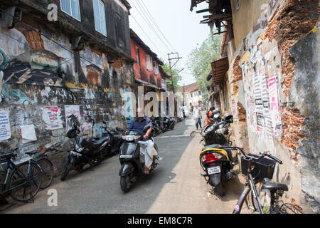 Ein Mann auf einem Motorrad durch eine Straße in Fort Kochi, Kerala Indien Stockfoto