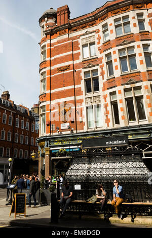 London, UK. 17. April 2015. Zwei Menschen sitzen außen Attendant, eine W1-Café-Bar bei gutem Wetter. Bildnachweis: Dave Stevenson/Alamy Live-Nachrichten Stockfoto