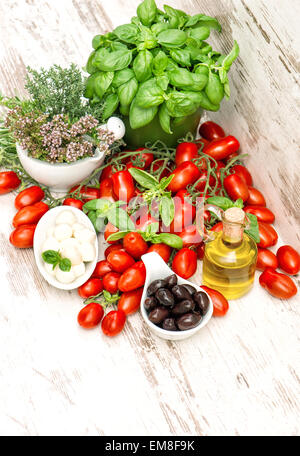 Frische Kräuter Basilikum, Tomaten, Mozzarella und Olivenöl. Gesunde Ernährung-Hintergrund. Caprese Salatzutaten Stockfoto