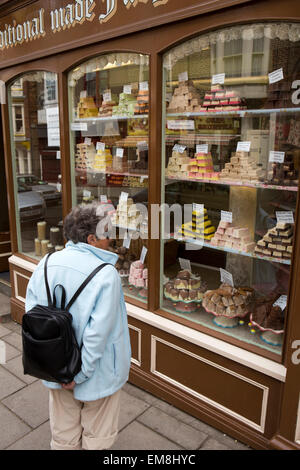 Großbritannien, England, Yorkshire, Scarborough, Eastborough, ältere Frau auf der Suche in alten altmodischen Fudge Schaufenster Stockfoto