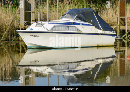 kleines Boot festgemacht an einem Fluss mit seiner Spiegelung im Wasser. Stockfoto