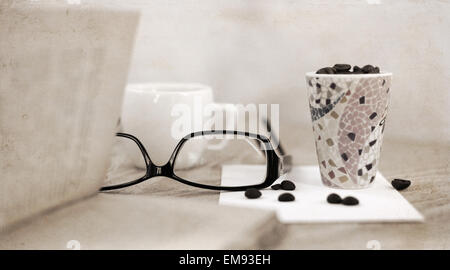 Kunstwerke im Retro-Stil, stilvolle Gläser, Tasse Kaffee Bohnen Stockfoto