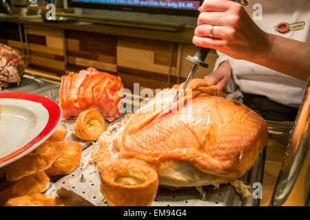 Toby Pub Koch schnitzen eine Fuge von Fleisch in ein Pub Fleischbuffet Stockfoto