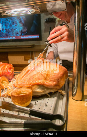 Toby Pub Koch schnitzen eine Fuge von Fleisch in ein Pub Fleischbuffet Stockfoto