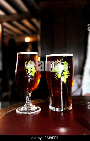 Pint Glas und halbes Pint Glas mit "Harveys" Best Bitter Bier serviert in der John Harvey Taverne in Lewes Stockfoto