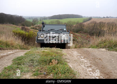 Land Rover Defender fahren abseits der Straßen cresting einen Hügel Stockfoto