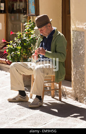 Alter Mann sitzt in der Straße, Montalcino, Toskana, Italien Stockfoto