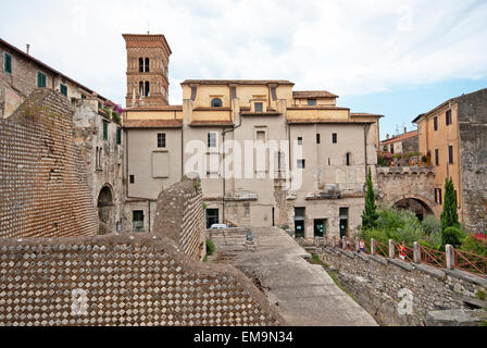 Terracina, Ruinen von Capitolium zwischen Häusern und oben auf dem Glockenturm des Doms, Latium, Italien Stockfoto