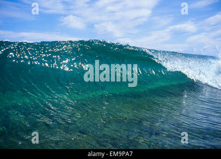 Hawaii, Eisstockschießen Welle über flaches Riff, blauer Himmel mit Wolken. Stockfoto