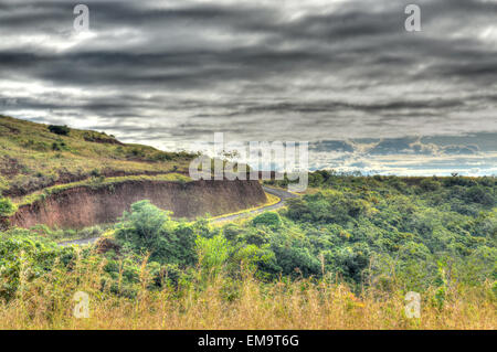 Ländliche Bergstraße mit einem dramatischen Himmel im Hintergrund Stockfoto