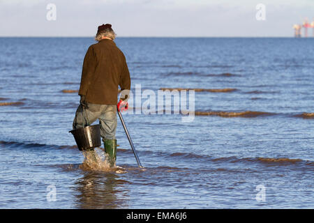 Southport, Merseyside, UK. 18. April 2015. UK Wetter: Köder Fischer die Ebbe in der Morgendämmerung. Als die Flut wird dann die Suche nach Köder wird einfacher als die Fischer mit einem Köder Pumpe keine Würmer, die Oberfläche Aktivität zu extrahieren. Diese Würmer, entweder lug oder weißer Lappen Wurm, werden dann für einen Club boot Angeltour am folgenden Tag, eine übliche traditionelle Sonntag Aktivität verwendet wird. Stockfoto