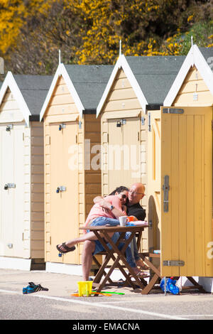 Bournemouth, Dorset, UK. 18. April 2015. Paar, entspannend und umarmen, sitzen in der Sonne draußen Strandhütte Credit: Carolyn Jenkins/Alamy Live News Stockfoto