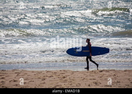 Bournemouth, Dorset, UK. 18. April 2015. Surfer, die ins Meer holding Surfbrett am Strand von Bournemouth in sehr windigen Wetterbedingungen im März Credit: Carolyn Jenkins/Alamy Live News Stockfoto