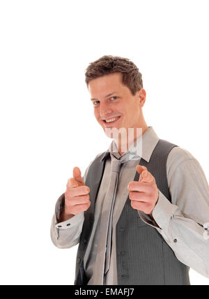 Ein junger Mann stehen und deutete mit dem Finger, in einem grauen Hemd und Weste, isoliert auf weißem Hintergrund. Stockfoto