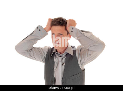 Ein junger Mann in einem grauen Hemd und Krawatte mit einer Weste auf, kratzte sich am Kopf zu seinem Problem, isoliert auf weißem Hintergrund. Stockfoto