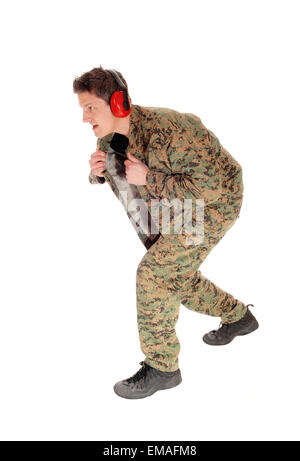 Ein einzelner Soldat in eine braune Tarnuniform und Gehörschutz zu Fuß für weißen Hintergrund isoliert. Stockfoto