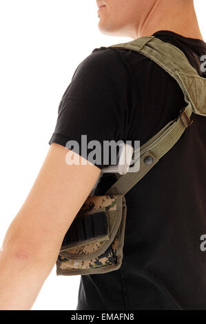 Ein Soldat in schwarz isoliert T-shirt mit seiner Waffe im Holster, eine Nahaufnahme von hinten, auf weißem Hintergrund. Stockfoto