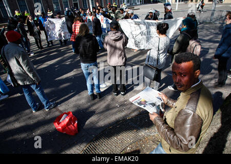 Amsterdam, Niederlande. 17. April 2015. Ein Mann, der Zugehörigkeit zu einer Gruppe von Asylsuchenden, die einen Tagesausflug in die politische Hauptstadt von Amsterdam gemacht haben sieht man liest eine Zeitung mit einem Foto von Ministerpräsident Mark Rutte deren rechten Flügel Ängste Partei Unterstützung zu verlieren. Mister Rutte Partei ist unter dem Druck seiner linken Flügel Koalitionspartei PvdA zu milderen gegenüber Einwanderern und Flüchtlingen. Bildnachweis: Willem Aires/Alamy Live-Nachrichten Stockfoto