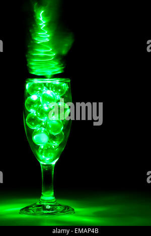 Klar, Murmeln in ein Weinglas mit grünes Licht Malerei Stockfoto
