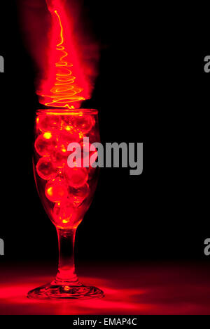 Klar, Murmeln in ein Weinglas mit Rotlicht-Malerei Stockfoto