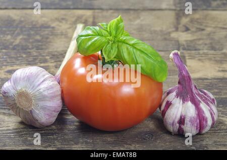 Tomaten, Knoblauch und Basilikum auf alten board Stockfoto