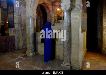 Eine christliche Gläubige betet am Altar der Heiligen Helena in der Kapelle St. Helena, die Helena, der Mutter von Kaiser Konstantin, gewidmet ist und der Überlieferung nach, die das Kreuz bei ihrem Besuch 326 n. Chr. in der Grabeskirche in der Altstadt von Jerusalem, Israel, entdeckte Stockfoto