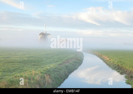 im Morgennebel Fluss, Holland Windmühle Stockfoto