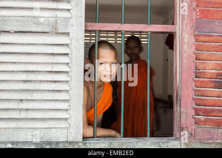 Ein junger Mönch Blick durch Fenster. Stockfoto