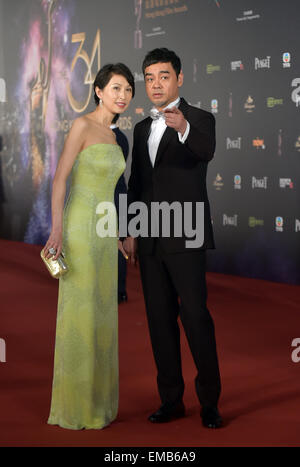 Hong Kong, China. 19. April 2015. Ching Wan Lau (R), nominiert für den besten Schauspieler, geht mit seiner Frau Amy Kwok vor der 34. Hong Kong Film Awards Verleihung in Hongkong, Südchina, 19. April 2015 den roten Teppich. © He Jingjia/Xinhua/Alamy Live-Nachrichten Stockfoto