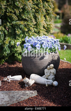 Frühling Blumen am Friedhof in Deutschland. Grab mit Oster-Deko. Flachen DOF, Fokus auf Blumentopf Stockfoto