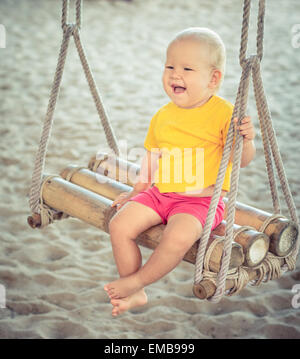 Baby-sitting auf einer Bambus-Schaukel Stockfoto