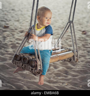 Baby-sitting auf einer Bambus-Schaukel Stockfoto