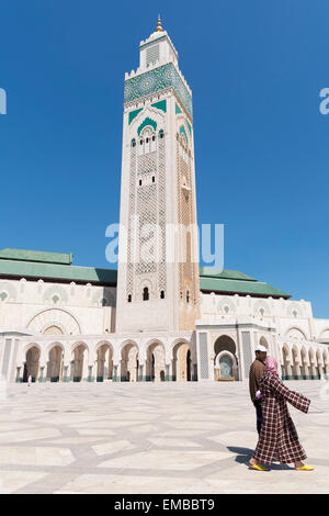 Muslimische Paare, die an der Hassan II Moschee in Casablanca, Parc de la Ligue Arabe, Casablanca, Marokko, vorbei laufen Stockfoto