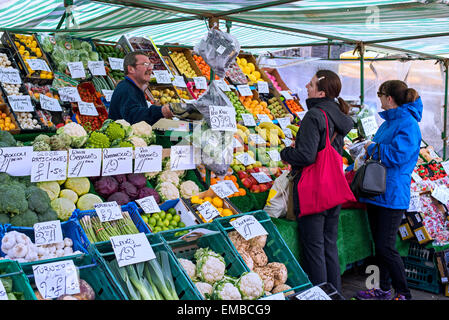 Ein Standbesitzer Dienst am Kunden an Obst und Gemüse Stand in der Grassmarket, Edinburgh. Stockfoto