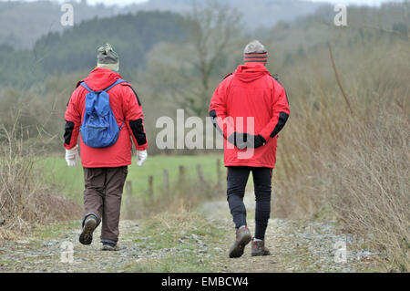 Alte weisen ein paar Spaziergänge und Wanderungen im Land auf einem Wanderweg im Winter. Diese Wanderer sind Sport unter freiem Himmel genießen. Stockfoto