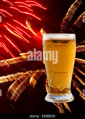 Schaum-Bierglas auf bunten Feuerwerk Hintergrund. Stockfoto