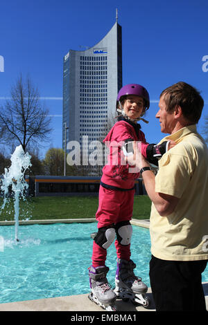 Ein Mann und ein Mädchen verbringen ihre Freizeit mit Inline Skating vor dem City-Hochhaus. Leipzig, Innenstadt, Deutschland. Stockfoto