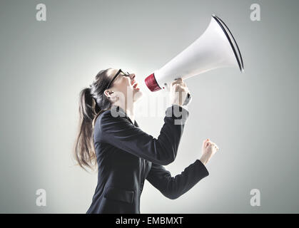 Porträt von eine hübsche Geschäftsfrau, die über das Megaphon schreien Stockfoto