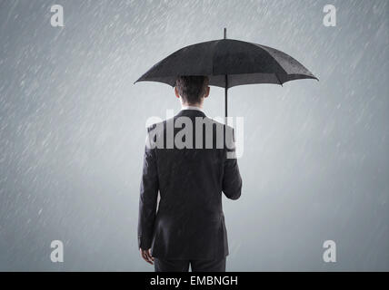 Junge intelligente Geschäftsmann im schweren Regen stehen Stockfoto