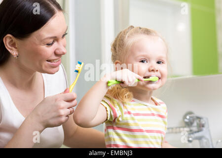 Mutter lehrt Kinder Zähne putzen Stockfoto