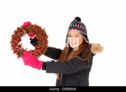 Eine Nahaufnahme Bild von einem jungen hübschen Mädchen hält einen bunten aufkommen Kranz in eine Jacke, Handschuhe und Mütze, isoliert auf weiß b Stockfoto