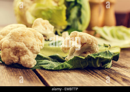 Rohen Blumenkohl mit Blatt auf Holztisch Stockfoto