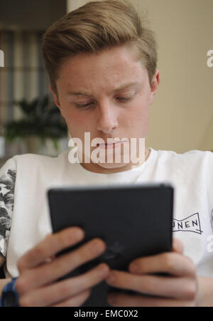 Teenage Boy Verwendung An Apple iPad Tablet Stockfoto