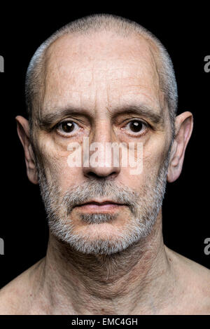 Dramatische Farbe Portrait eines erwachsenen Mannes mit traurigen Ausdruck auf schwarzem Hintergrund Stockfoto