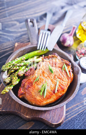 gebratenes Fleisch mit Spargel in der Pfanne Stockfoto