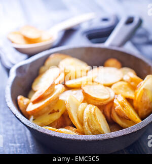 Bratkartoffeln in der Pfanne und auf einem Tisch Stockfoto