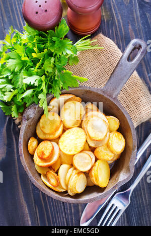 Bratkartoffeln in der Pfanne und auf einem Tisch Stockfoto