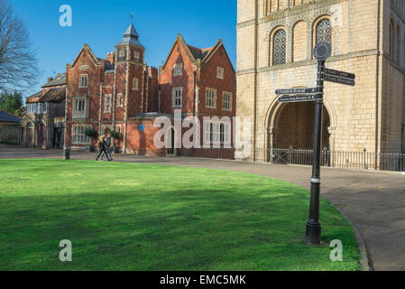 Ein junges Paar die normannischen Turm und viktorianischen Sparkasse Haus in der Großen Kirchhof (Kathedrale), Bury St. Edmunds, Suffolk, Großbritannien. Stockfoto