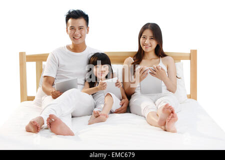 Eine Familie mit drei in das Schlafzimmer mit einem Tablet-computer Stockfoto